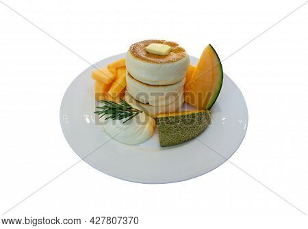 White Fluffy Pancake And Butter Topping On White Ceramic Plate Decorated With Yellow And Green Melon