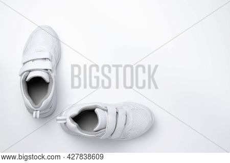 Flat Lay Two White Unisex Sneakers With Velcro Fasteners At A 90 Degree Angle To Each Other Isolated
