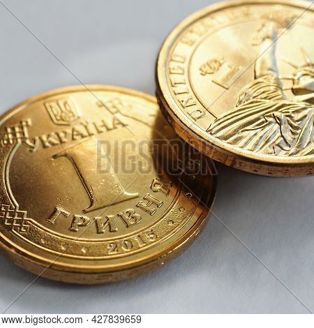 Translation: Ukraine, Hryvnia. Ukrainian Coin In 1 Hryvnia And Us One In One Dollar. Hang Over A Whi