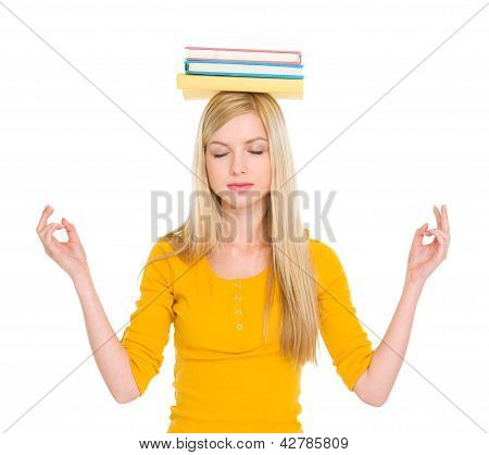 学生の女の子の瞑想の頭の上の本