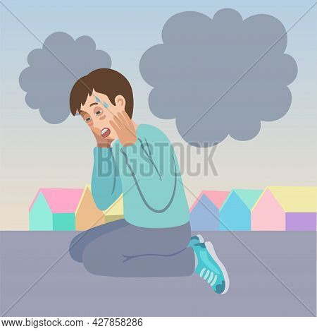Scared Young Man With Panic Attack And Agoraphobia, Sitting On The Street With His Head In His Hands