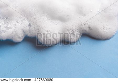 Face Cleansing Mousse Sample. White Cleanser Foam Bubbles On Blue Background, Copy Space. Soap, Show