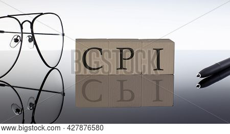 Close-up Of Cpi Wooden Blocks On Black Background With Glasses And Pen