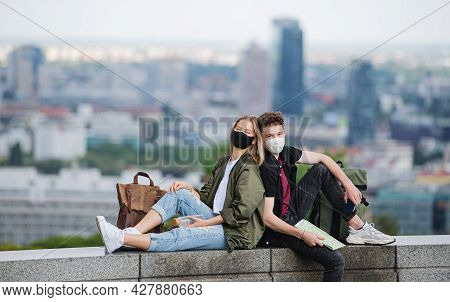 Young Couple Travelers With Map Looking At Camera In City On Holiday, Coronavirus Concept.
