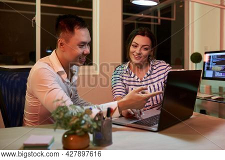 Smiling Project Manager And Softwear Developer Sitting At Office Table And Discussing Finished Proje