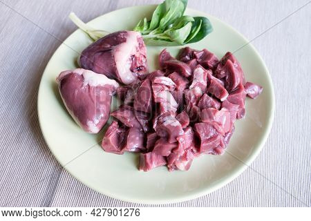 Raw Turkey Heart Lies On A Plate. Turkey By-products Are Sliced For Cooking. Raw Meat For Pets. Hear