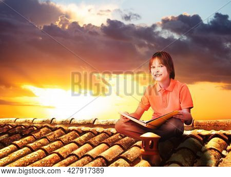 Boy Sit On A Roof And Read Book, View Over Sunset
