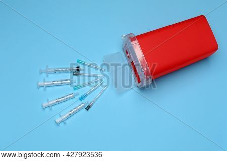 Disposable Syringes, Needles And Sharps Container On Light Blue Background