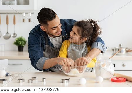 Father Daughter Leisure. Happy Arab Dad Baking With Female Child In Kitchen