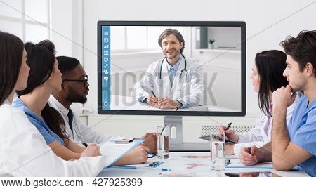 Team Of Diverse Doctors Having Online Meeting In Clinic Office