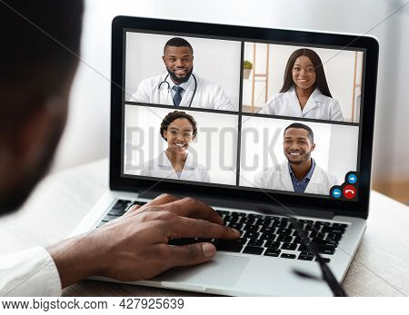 African Male Doctor Making Video Call Consulting With Colleagues Indoor