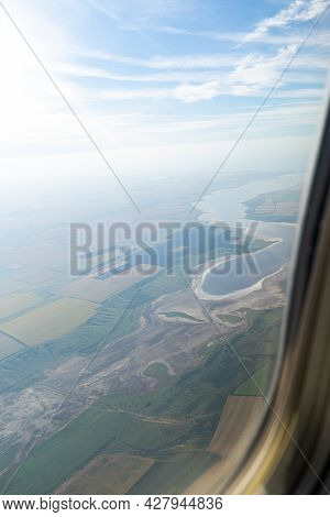 Land View Through The Airplane Window. Fields, Roads, Rivers From A Birds Eye View. Porthole. Look O