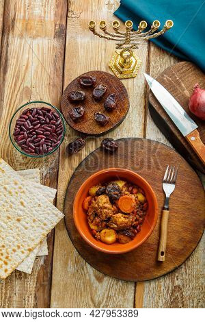 Jewish Dish Cholent With Meat Ingredients And Menorah On The Table. Vertical Photo