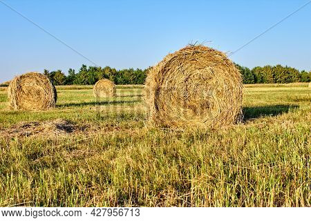 Three Bales Of Hay In A Field Photo At Sunset
