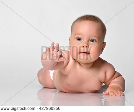 Baby Chubby In One Diaper Lies On The Light Floor And Lifted The Handle Up.