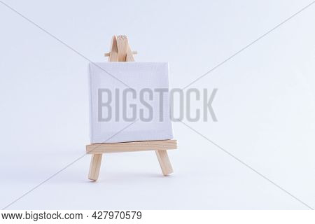 Wooden Easel Miniature With Blank White Square Canvas For Artists And Painters - Mockup. Mini Wooden