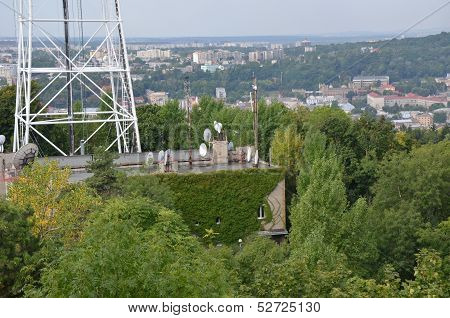 Roofs of city Lviv and television tower with trees