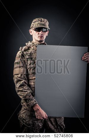 Modern Soldier Is Holding A Poster