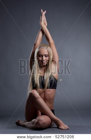 Image of becalmed blonde doing yoga in studio