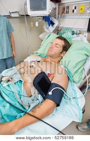 Male patient with holter monitor sleeping in examination room at hospital