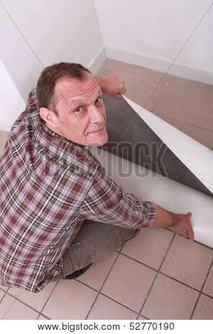 Man unrolling carpet