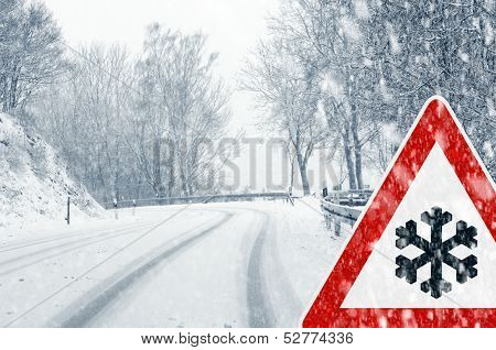 Snowy curvy road with traffic sign