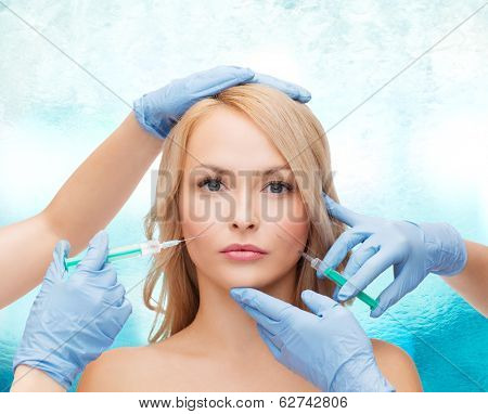 beauty and cosmetic surgery concept - woman face and beautician hands with syringes