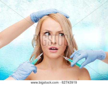 beauty and cosmetic surgery concept - woman face and beautician hands with syringes