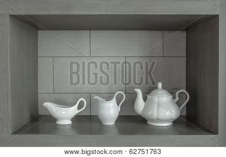 3 white tea pot set on the gray wall