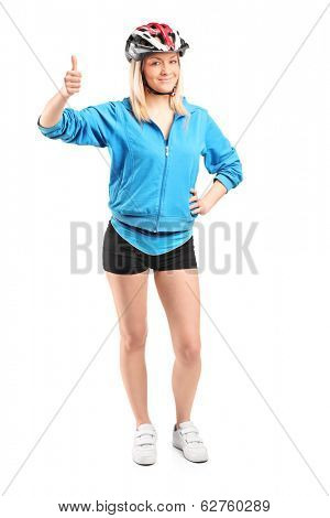 Full length portrait of a female cyclist giving thumb up isolated on white background