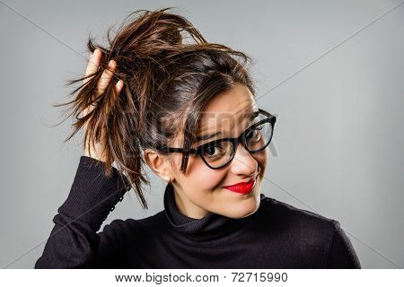 Real girl with glasses and red lips touching her hair bun