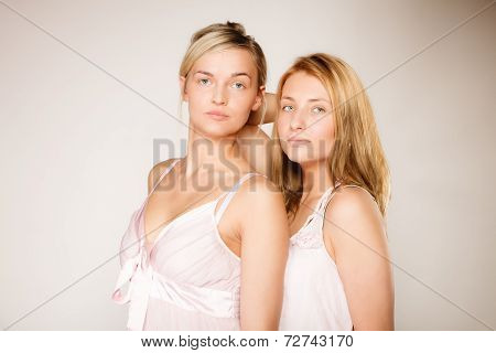 Two Blonde Women With No Makeup On Gray