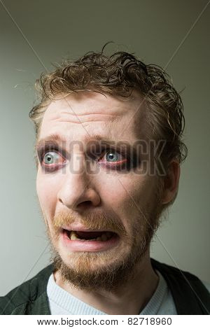 frightened man with red painted eyes.