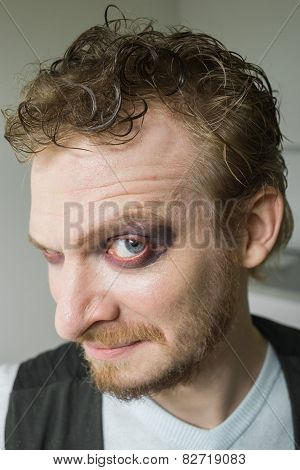 cunning man with red painted eyes.