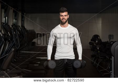 Young Man Exercising Biceps With Dumbbells