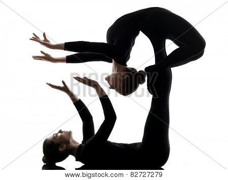 two women contortionist practicing gymnastic yoga in silhouette on white background