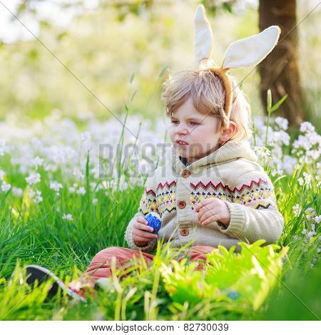 Cute Happy Little Boy Wearing Easter Bunny Ears At Spring Green Grass
