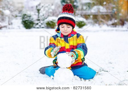 Funny Preschool Boy In Colorful Clothes Making A Snowman