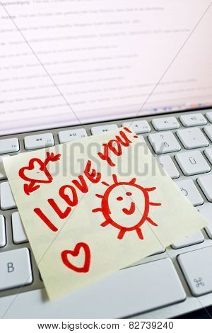 a memo is on the keyboard of a computer as a reminder i love you