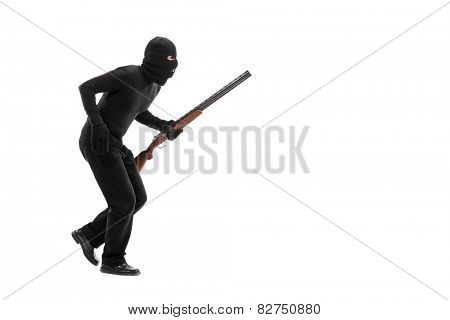 Stealthy criminal with a mask and a rifle walking isolated on white background