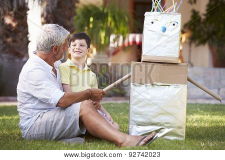 Grandfather And Grandson Building Model Robot In Garden