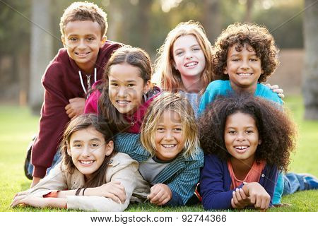 Group Of Children Lying On Grass Together In Park