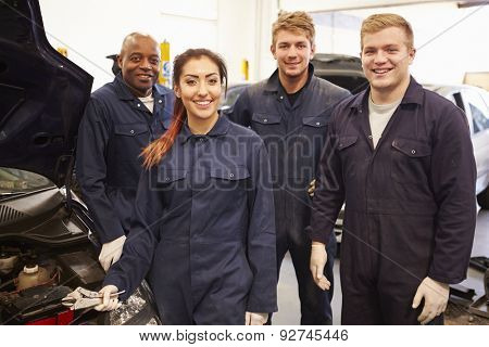 Teacher Helping Students Training To Be Car Mechanics