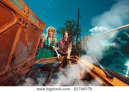 Beautiful Woman Mecanic Is Repairing A Car Another Woman Is Watching.