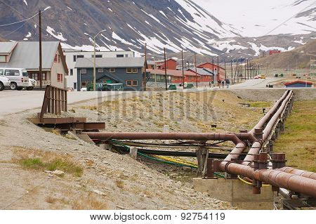 View to the street of Longyearbyen with heating pipes at the foreground in Longyearbyen, Norway.