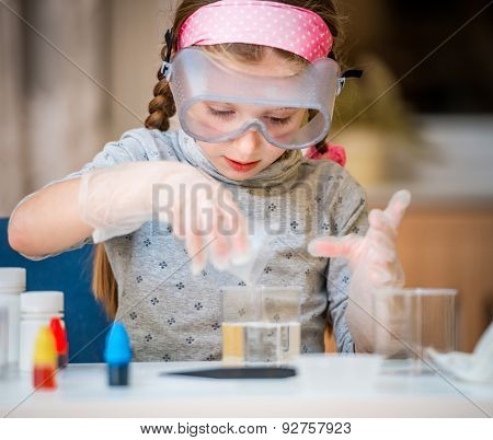 happy little girl with flasks for chemistry