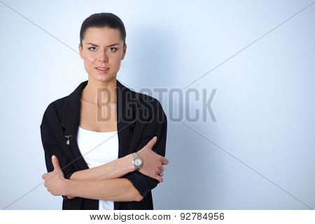 A young woman standing, isolated on graybackground