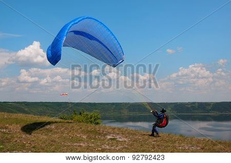 Paraglider Prepares To Fly Over Beautiful Bakota Reservoir.