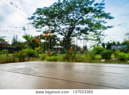Wooden Table in park nature with big tree for backdrop and background.