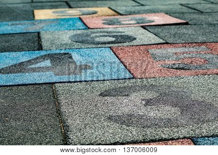 Colored numbered rubber floor tiles for playing hopscotch